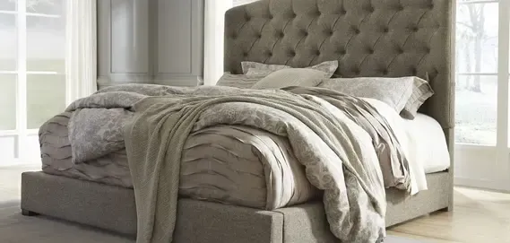 A cozy tufted bed dressed in soft