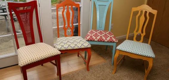 Four colorful chairs with patterned cushions in a bright room